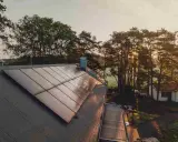 Solpaneler på ett tak i solnedgången, en vacker vy av Svea Solar AB:s arbete.