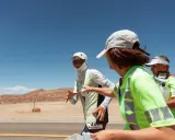 Läufer beim Badwater 135 Ultra-Marathon in der Wüste. Eine Helferin reicht einem Läufer Wasser.