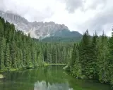 Laghi alpini nella Val di Fassa, circondati da fitti boschi di conifere e imponenti vette rocciose.