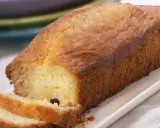 Un cake doré, parfait pour une recette facile. Deux tranches sont coupées, révélant une mie moelleuse et quelques raisins secs.