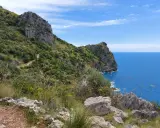 Sentiero panoramico con rocce e vegetazione lussureggiante che si affaccia sul mare blu intenso. Un'ottima idea per cosa vedere a Sapri.