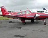 Roter Beechcraft Baron mit zwei Propellern auf dem Flugplatz.