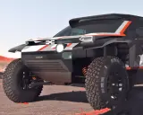 Un vehículo Dacia Dakar futurista, con diseño agresivo y neumáticos todoterreno, listo para conquistar cualquier desafío en un paisaje desértico.