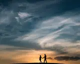Coppia in silhouette al tramonto, un'immagine che evoca una poesia per 60 anni di matrimonio, un amore che dura nel tempo.
