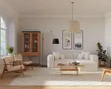 Ein Wohnzimmer im skandinavischen Design-Stil mit beiger Couch, Holzboden und einem Schrank.