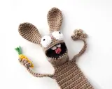 Un divertido conejo amigurumi de crochet, con ojos saltones y una zanahoria en la mano, parece listo para una aventura.