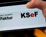 Palec dotyka ekranu telefonu z napisem "Krajowy System e-Faktur KSeF". To część polskiego ładu w finansach.