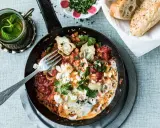 Herzhaftes Menemen ohne Ei mit Artischocken und Feta, garniert mit Petersilie. Dazu frisches Brot und Minztee.