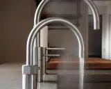 Zwei moderne Küchenarmaturen aus Edelstahl, eine davon mit Dampf. Gute Erfahrungen mit elektrischer Wasserhahn.