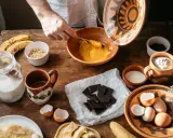 Préparation d'une recette avec des ingrédients comme des œufs, des bananes et du chocolat qui ne fond pas.