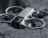 Szary dron DJI Avata 3 z kamerą z przodu, unoszący się w powietrzu.