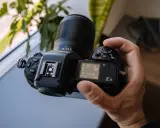 Dłoń trzyma aparat Nikon Z8 z obiektywem 35/1.8 S. Ekran pokazuje ustawienia, a cena tego modelu jest atrakcyjna.