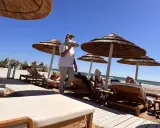 Kellnerin bringt Getränke an Liegestühle am Strand. Perfekte Feiertage Spanien!