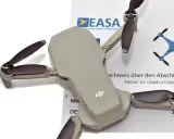 Graue Drohne liegt auf einem EASA-Zertifikat. So kann man legal eine **Drohne ohne Registrierung fliegen**.