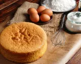 Biscuit Joconde doré, prêt pour la recette de Cyril Lignac. Œufs, farine et sucre à portée de main.
