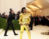 Lil Nas X, un caballero dorado, posa en la alfombra de la Met Gala, rodeado de fotógrafos y admiradores.