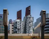 Iconica Nakagin Capsule Tower, un capolavoro di architettura modulare con capsule cubiche impilate, si staglia contro il cielo azzurro.
