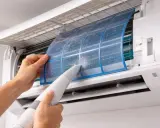 Nettoyage d'un filtre de climatisation poussiéreux. Un entretien régulier prolonge la durée de vie climatisation et assure un air sain.