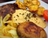 Stek z aromatycznym sosem z zielonego pieprzu, podany z pieczonymi ziemniakami, karmelizowaną cebulką i pomidorem.