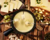 Fondue au fromage, une des spécialités d'Auvergne, accompagnée de pain, raisins et tomates cerises.