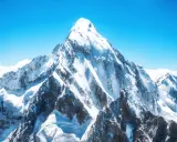 Majestatyczny szczyt pokryty śniegiem, symbolizujący ogromną mount everest wysokość. Błękitne niebo i chmury podkreślają jego potęgę.