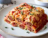 Pyszne cannelloni z mięsem mielonym, zapieczone pod sosem pomidorowym i serem, ozdobione gałązkami tymianku.
