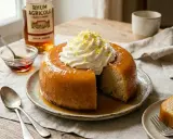 Un baba au rhum moelleux, nappé de sirop et garni de chantilly, prêt à être dégusté. Une invitation à la gourmandise.