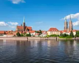 Widok na Ostrów Tumski we Wrocławiu, perłę Dolnego Śląska, z rzeką w tle.