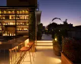 Terrazza panoramica con bar illuminato e sedie, ideale per scoprire le cose da fare a Roma nel weekend.