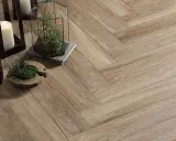 Detalles de cómo colocar azulejos en espiga, con velas y plantas decorativas sobre el suelo de madera.