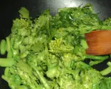Cime di rapa salteados en sartén con una cuchara de madera. Verduras verdes vibrantes y frescas, listas para ser disfrutadas.