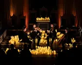 En stråkkvartett spelar bland hundratals levande ljus under en magisk candlelight concert.