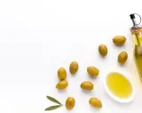 Botella de aceite de oliva virgen extra y aceitunas verdes. El mejor aceite de oliva para tomar crudo, con un sabor fresco y puro.