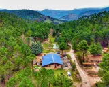 Un refugio en el bosque, el lagunazo riopar, rodeado de pinos y con un estanque sereno.