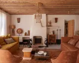 Ambiance chaleureuse dans cet **intérieur maison île de Ré**. Canapés confortables, cheminée imposante et plafond en bois créent un cocon douillet.