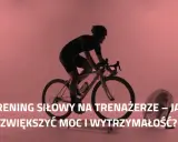 Kolarz w kasku intensywnie trenuje na trenażerze, by zwiększyć moc i wytrzymałość. Obok stoi wentylator.
