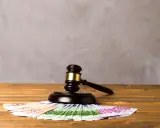 Młotek sędziowski na euro symbolizuje alimenty ojca w Polsce, gdy dziecko mieszka za granicą.