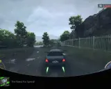 Trofea NFS Unbound zdobyte! Widok z gry na samochód jadący po mokrej drodze, z zielonymi płomieniami z wydechu.