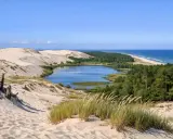 Słowiński Park Narodowy atrakcje: ruchome wydmy, jezioro Łebsko, lasy i morze. Widok z wydmy na krajobraz.