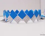 Eine selbstgebastelte Geburtstagskrone aus Papierstreifen, blau und weiß, mit Text bedruckt. Perfekt zum Geburtstagskrone basteln!
