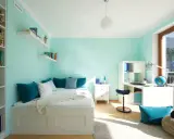 Habitación juvenil con paredes verde menta. La decoración combina tonos turquesa en cojines y accesorios, creando un ambiente fresco y moderno.