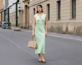 Elegancka zielona sukienka z beżową torebką i brązowymi balerinkami – idealne dodatki do zielonej sukienki na miejski spacer.