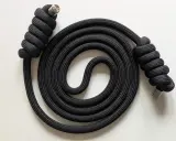 Schwarzes Seil mit Metallenden, kunstvoll zu einer Spirale gewickelt. Der rope flow erzeugt ein faszinierendes Muster.