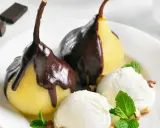 Poires pochées nappées de chocolat noir, servies avec de la glace à la vanille et des éclats de noisettes. Un délice de poire Belle Hélène.