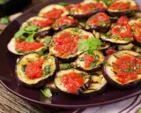 Fette di melanzane grigliate condite con salsa di pomodoro e basilico, un gustoso piatto di melanzane alla pizzaiola.