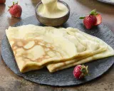 Délicieuses crêpes de riz garnies de crème vanillée, accompagnées de fraises fraîches. Un délice gourmand.