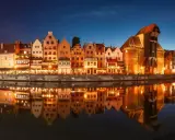 Nadmorska panorama Gdańska nocą, z odbijającymi się w wodzie kamienicami i Żurawiem. Idealne miejsce na zaręczyny Polska.