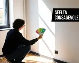 Persona valuta campioni di colore per decidere come scegliere colore pareti.