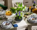 Stół wielkanocny inspiracje: białe tulipany, hiacynty, babka, babeczki, złote i miedziane jajka, porcelana z niebieskim wzorem.