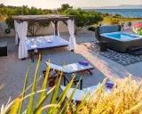 Relaks przy morzu: leżaki, jacuzzi i baldachim w chorwackim apartamencie.